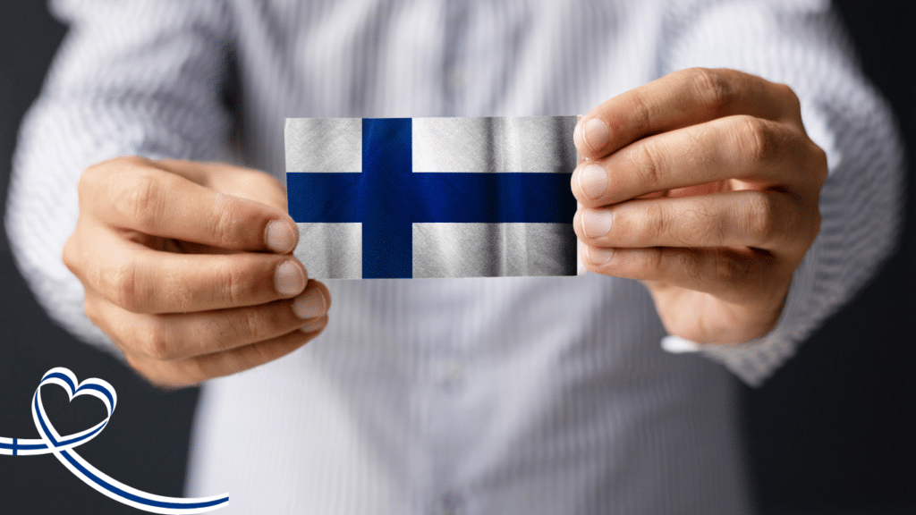 Henkilö pitelee Suomen lippua käsissään – 100 % kotimainen valinta ja suomalainen laatu.