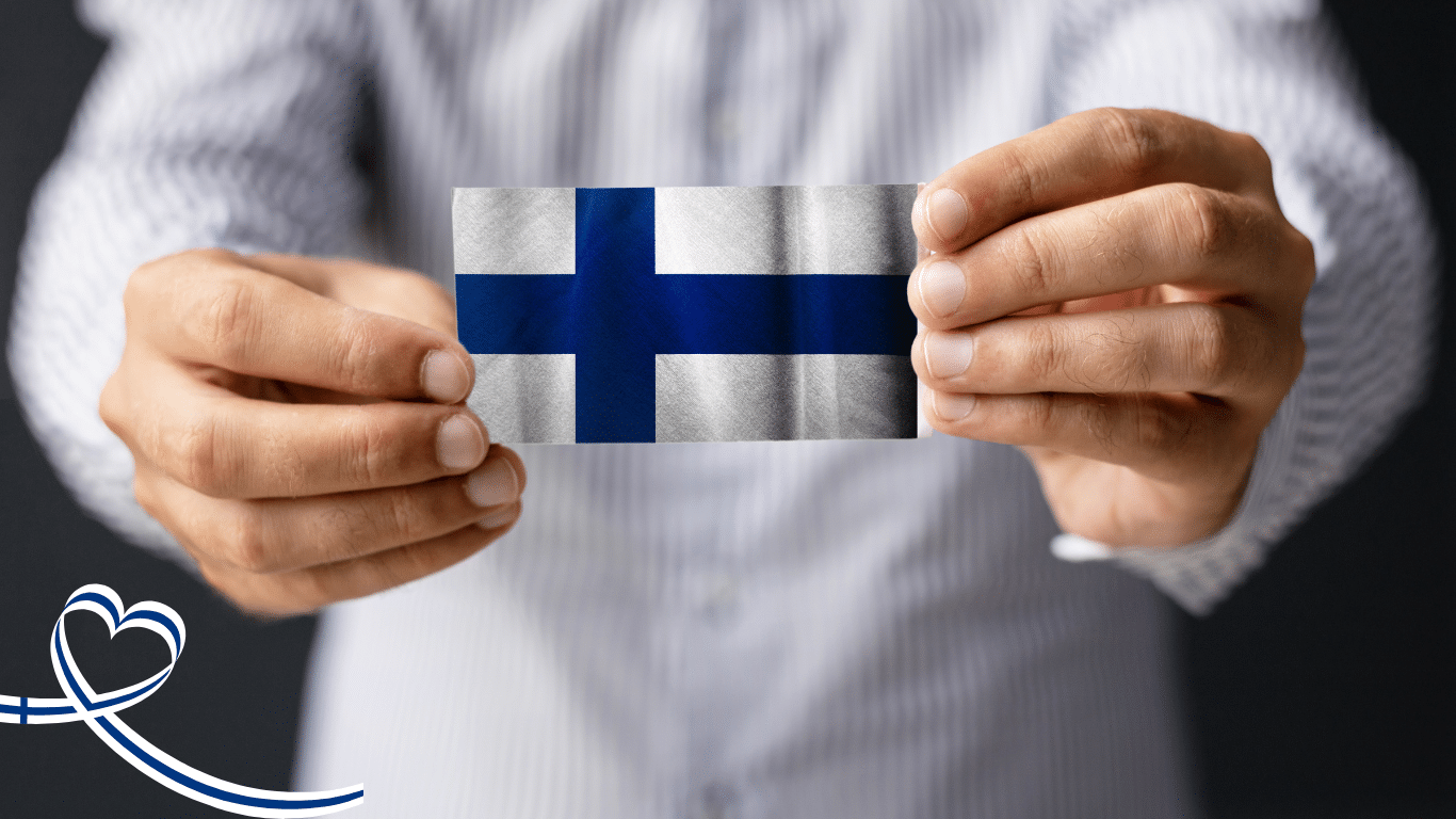 Henkilö pitelee Suomen lippua käsissään – 100 % kotimainen valinta ja suomalainen laatu.